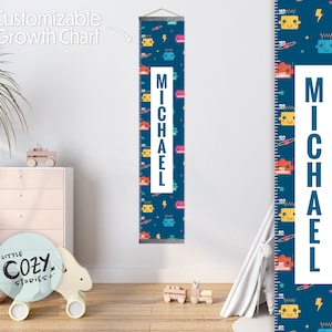 Può includere: Un grafico di crescita blu e bianco a tema robot. Il grafico presenta un rettangolo bianco con il nome "MICHAEL" stampato in lettere blu. Il grafico è decorato con robot colorati, stelle e fulmini.