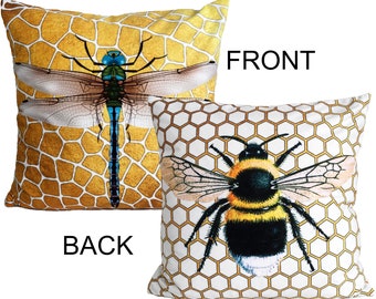 May include: Two decorative pillow covers with a honeycomb pattern. One pillow features a blue dragonfly on a gold background. The other pillow features a bumblebee on a white background with gold honeycomb.