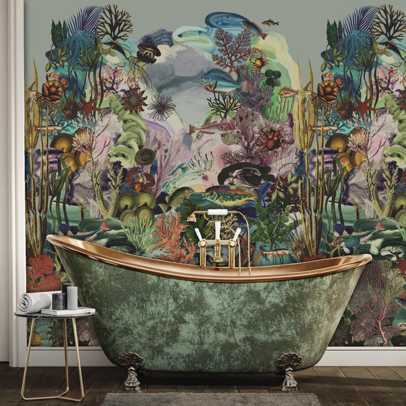 May include: A stylish green bathtub with copper edging and decorative feet is positioned in front of a colourful mural of an underwater scene, featuring coral, fish, and aquatic plants. A small side table holds candles and a rolled towel.