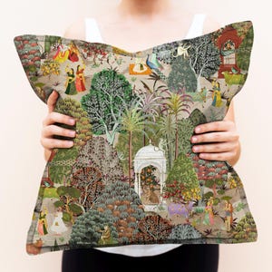 Puede incluir: Una almohada decorativa con un dise&ntilde;o colorido e intrincado que presenta una escena de jard&iacute;n exuberante con pavos reales, monos y personas. La almohada est&aacute; hecha de una tela suave y texturizada y tiene un fondo beige.