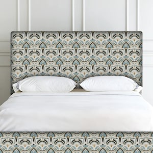 May include: A patterned headboard with a repeating geometric design in shades of blue, beige, and brown. The headboard is positioned above a bed with white bedding and pillows. The design is symmetrical and creates a visually appealing focal point.