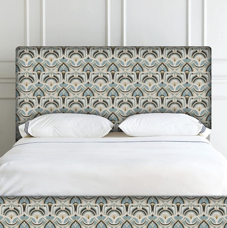 May include: A patterned headboard with a repeating geometric design in shades of blue, beige, and brown. The headboard is positioned above a bed with white bedding and pillows. The design is symmetrical and creates a visually appealing focal point.