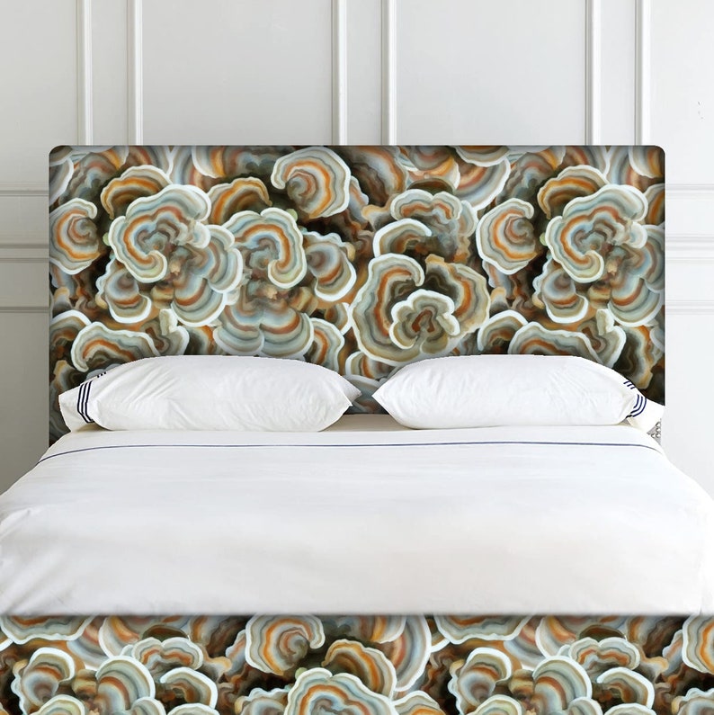 May include: A white bed with a headboard featuring a mushroom-like pattern in shades of brown, gray, and white.