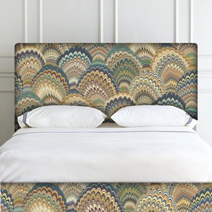 K&ouml;nnte beinhalten: Ein wei&szlig;es Bett mit einem gemusterten Kopfteil und Fu&szlig;teil. Das Kopfteil und das Fu&szlig;teil weisen ein wirbelndes, abstraktes Design in Blaut&ouml;nen, Gr&uuml;n, Gelb und Braun auf.