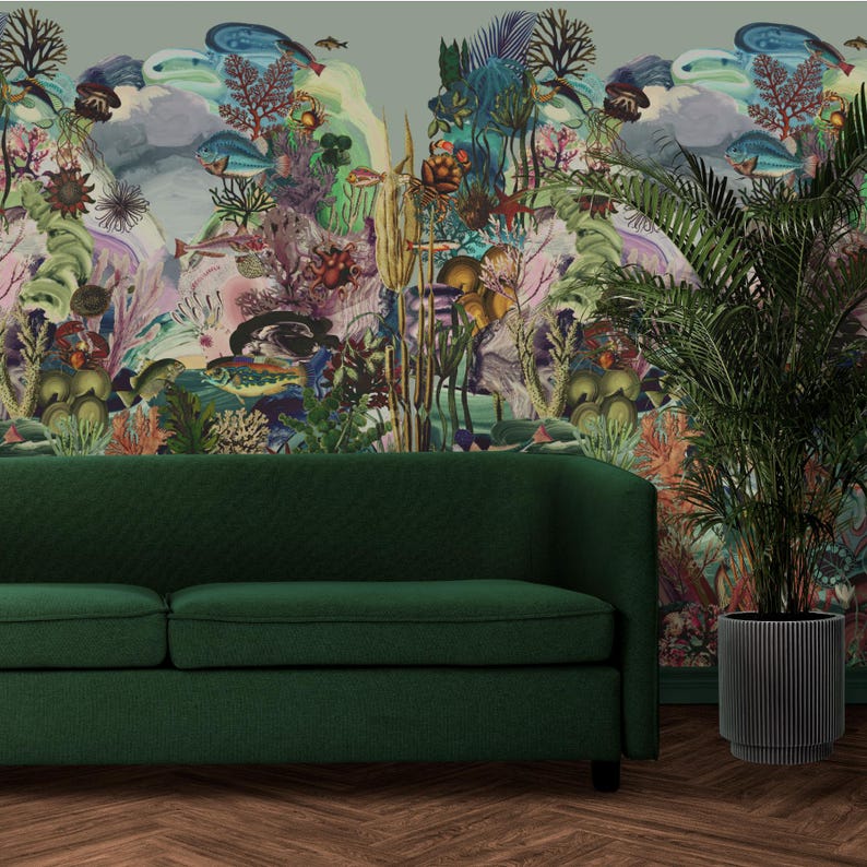 May include: A dark green sofa with textured fabric is positioned before a vibrant mural of an underwater scene, featuring fish, coral, and plants. A potted plant in a black, ribbed planter is to the right. The room has a hardwood floor.