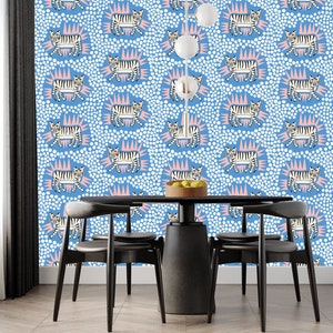 May include: A dining room with a blue and white wallpaper featuring a repeating pattern of white tigers with pink accents. The wallpaper has a polka dot pattern. A black table with four black chairs is in the center of the room.