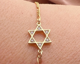 May include: A gold chain bracelet with a star of David pendant featuring clear cubic zirconia stones.
