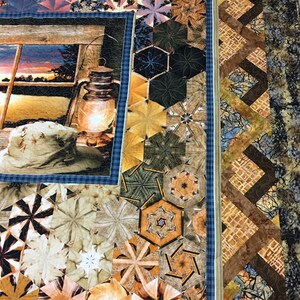 May include: A quilt with a patchwork design featuring a variety of geometric shapes and patterns in shades of brown, beige, and blue. The quilt has a border of brown and beige fabric with a geometric pattern. The quilt is made with a variety of fabrics, including cotton and linen.