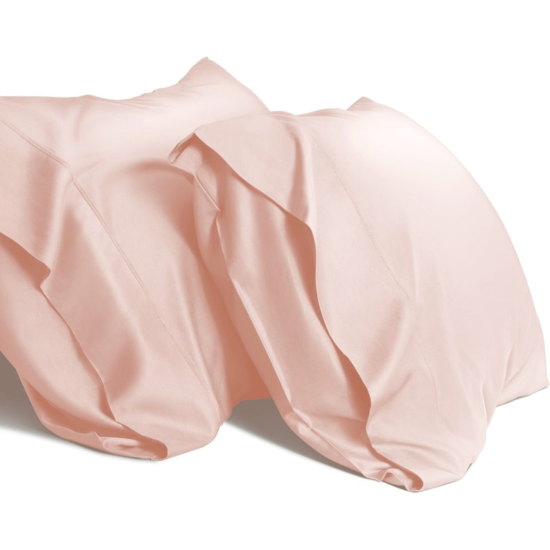 May include: Two blush pink pillowcases made of soft, smooth fabric. The pillowcases are folded and arranged on a white background.