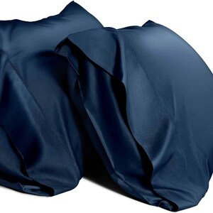 May include: Two dark blue pillowcases made of a soft, silky material. The pillowcases are folded and stacked on top of each other.
