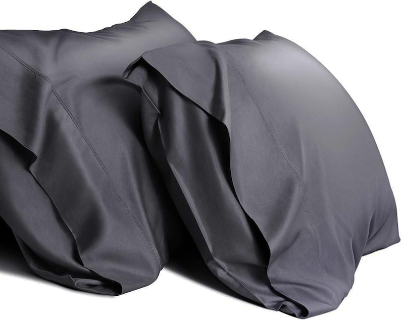 May include: Two gray pillowcases made of a soft, smooth fabric. The pillowcases are folded and stacked on top of each other.