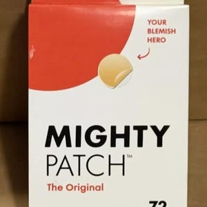 May include: A white and red box of Mighty Patch acne patches. The box reads "Hero" and "Jumbo Pack" at the top. The front of the box features the text "MIGHTY PATCH The Original" and "72 Hydrocolloid Patches".