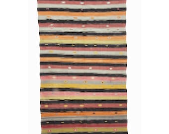 May include: A long, narrow, striped rug with a variety of colors, including red, orange, yellow, black, and gray. The rug has a simple, geometric pattern and is woven with a traditional technique.