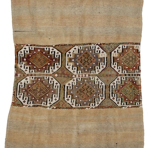 Puede incluir: Una alfombra vintage con fondo beige y un patrón geométrico colorido en el tercio inferior. El patrón presenta una serie de octógonos con diseños intrincados en tonos de rojo, verde, azul y marrón.