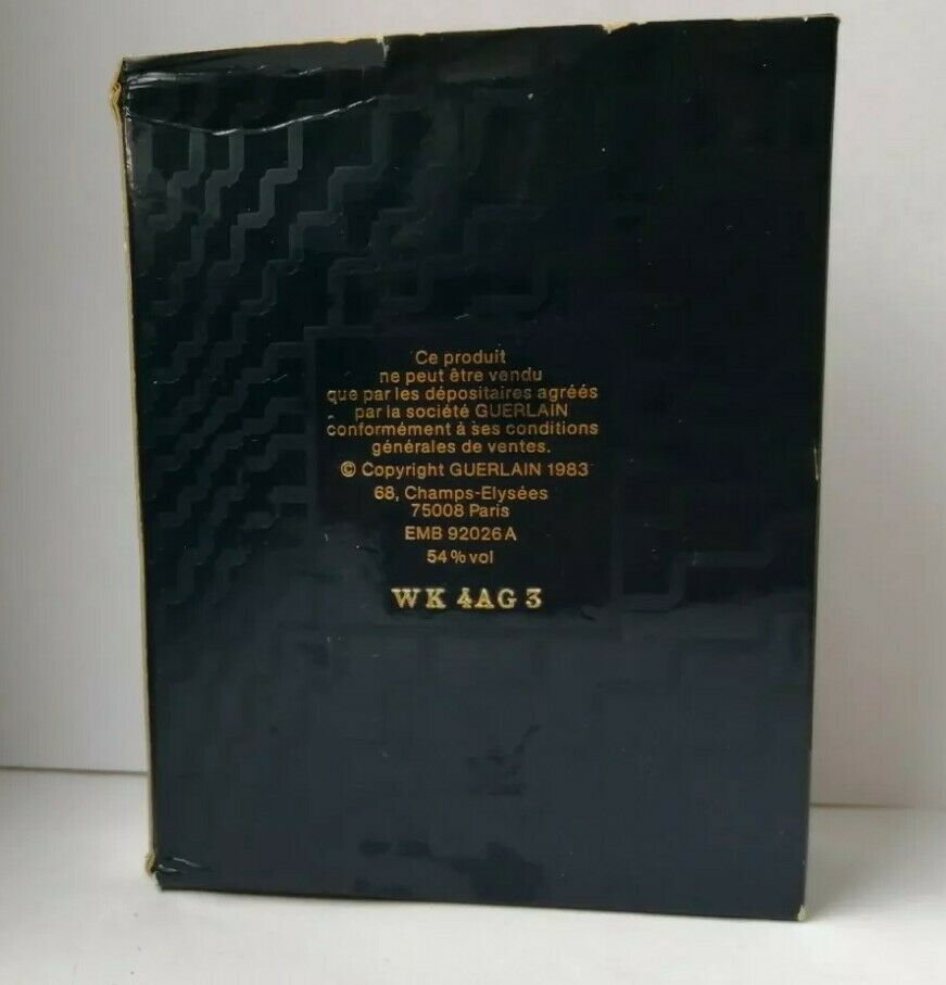 May include: A black box with gold geometric patterns and white text. The text includes "Copyright GUERLAIN 1983" and "54% vol". The box has a slightly worn appearance.