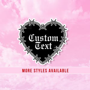May include: A black heart-shaped sticker featuring a white barbed wire border and the words Custom Text in a white gothic font. The design is centered and has a white outline, presented against a soft pink background with clouds.