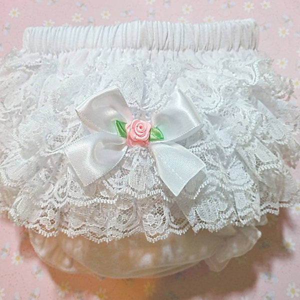 White diaper cover, bloomer, with 4 layers of lace, trimmed with a white satin bow and pink rosebud.  For baby girls and toddlers.