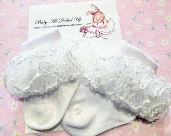 May include: White lace baby socks with a ruffled trim. The socks are made of soft, breathable fabric and are perfect for a special occasion.