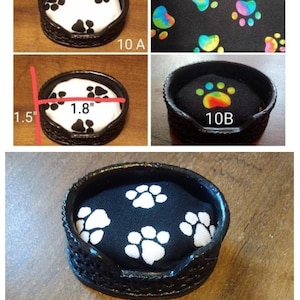 May include: A small, black pet bed with a woven exterior and a paw print design. The bed's interior is black with white paw prints. The bed is 1.8 inches wide and 1.5 inches tall. The text "10 A", "10 B", and "10 C" are visible.