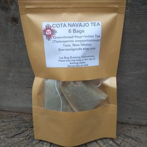 May include: A brown paper pouch containing 6 bags of Cota Navajo Tea. The label reads: COTA NAVAJO TEA, 6 Bags, Greenthread, Hopi, Indian Tea, Thelesperma megapotamicum, Taos, New Mexico, Sierrasolgoods.etsy.com, Tea Bag Brewing Instructions: Place one tea bag in 8oz cup of boiling water, Serve hot or cold.