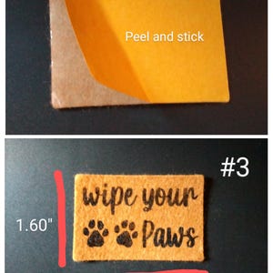 May include: A rectangular, peel-and-stick doormat with the text "wipe your paws" and paw prints. The doormat is 2.30 inches long and 1.60 inches wide. The backing is a light brown color, and the top is a light orange color.