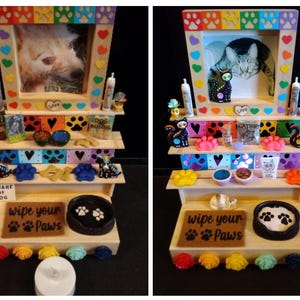 May include: A wooden pet display shelf with a framed photo of a dog and cat. The shelves are decorated with paw prints, hearts, and miniature pet supplies. The bottom shelf has a sign that reads "wipe your paws".