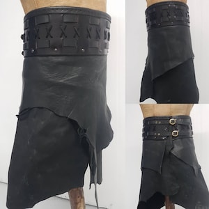 Puede incluir: Falda de cuero negro con un cinturón grueso de cuero trenzado. El cinturón tiene un patrón decorativo de X y está asegurado con remaches metálicos.