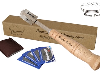 May include: A wooden bread scoring lame with a brown leather case and five replacement blades. The lame is engraved with "Rustic Baker" and the box is labeled "Premium Scoring Lame, Perfect for... Rustic Baker".