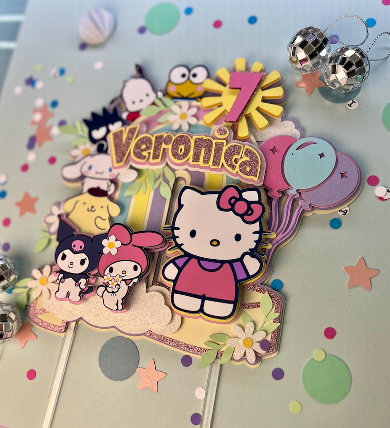 May include: A colorful cake topper featuring Hello Kitty, My Melody, and other cartoon characters. The topper includes a pink number 7, a yellow sun, and the name "Veronica" in pink glitter letters.