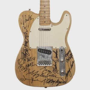 Può includere: Una chitarra elettrica colorata chiara con battipenna bianco e hardware cromato. Il corpo della chitarra è ricoperto di firme nere. La chitarra ha sei corde e un manico in acero. Uno strumento classico.
