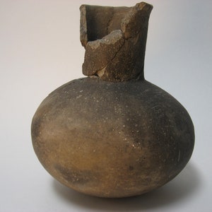 May include: A brown, ceramic, round-bodied vase with a broken neck. The vase is made of a rough, textured clay.