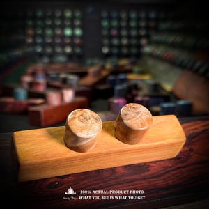 May include: A rectangular wooden block base with two cylindrical wooden knobs attached to the top. The wood features a light brown grain pattern with natural knots and swirls. Text at the bottom reads: 100% ACTUAL PRODUCT PHOTO WHAT YOU SEE IS WHAT YOU GET.