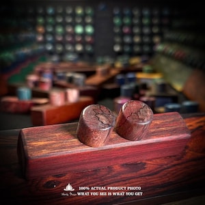 May include: A rectangular block of dark reddish-brown wood with two cylindrical wooden pieces resting on top. The wood features a prominent dark grain pattern throughout. Text at the bottom reads: 100% ACTUAL PRODUCT PHOTO WHAT YOU SEE IS WHAT YOU GET.