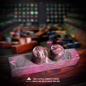May include: Two cylindrical plugs with a swirling purple and dark wood grain pattern resting on a rectangular wooden block featuring matching purple and dark wood grain. The text 100% ACTUAL PRODUCT PHOTO WHAT YOU SEE IS WHAT YOU GET is visible.