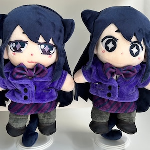 May include: Two plush toys of a girl with long black hair, wearing a purple jacket, a striped skirt, and a purple bow tie. The toys have large eyes with white stars and are holding their hands in front of them.