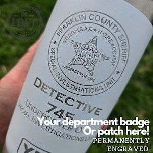 May include: White stainless steel tumbler with a silver engraved design. The design includes the words "Franklin County Sheriff", "Special Investigations Unit", "Undercover Ops", "Detective 745", and "Your department badge or patch here! Permanently Engraved."