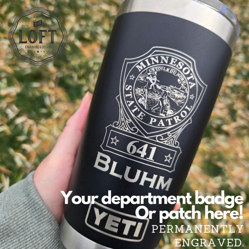 May include: A black Yeti tumbler with a silver lid and a laser engraved Minnesota State Patrol badge with the number 641 and the name Bluhm. The text "Your department badge or patch here! Permanently engraved." is also engraved on the tumbler.