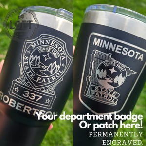 May include: A matte black stainless steel tumbler featuring a laser-engraved Minnesota State Patrol badge design. The engraving includes the text Minnesota State Patrol, Since 1929, the number 337, and the name Robertson, with a clear plastic lid.