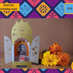 May include: A decorative Frida Kahlo-themed paper lantern with a portrait, a candle, and the name "FRIDA". The lantern is yellow and white, with cut-out designs. The background features marigold flowers and a patterned border with the text "DIGITAL DOWNLOAD" and "SVG".