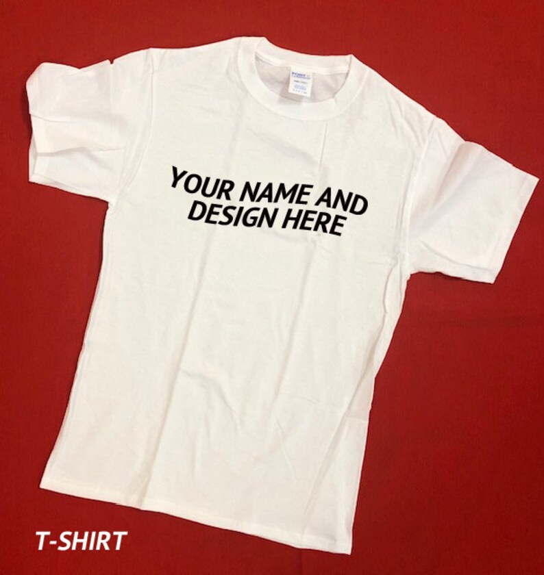 Peut inclure: T-shirt blanc avec le texte "YOUR NAME AND DESIGN HERE" imprim&eacute; en noir sur le devant.