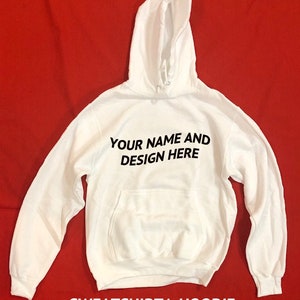 Peut inclure: Sweat-shirt &agrave; capuche blanc avec une capuche et une poche kangourou. Le texte "YOUR NAME AND DESIGN HERE" est imprim&eacute; sur le devant.