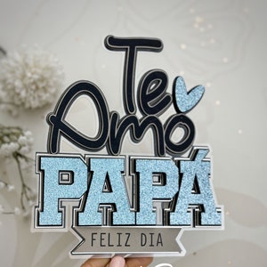 Może przedstawiać: Niebieski i czarny topper na ciasto z brokatem z tekstem "Te Amo Papa Feliz Dia" i podpisem "IMARU Rosas".