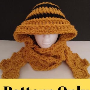 Puede incluir: Patrón de ganchillo para un gorro a rayas amarillo y negro y una bufanda a juego. El gorro tiene un ala ancha y la bufanda es de forma rectangular.