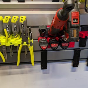 Puede incluir: Una colecci&oacute;n de herramientas, incluyendo alicates y herramientas el&eacute;ctricas, organizada en un sistema de almacenamiento montado en la pared. Las herramientas son una mezcla de herramientas manuales amarillas y negras y herramientas el&eacute;ctricas rojas y negras.