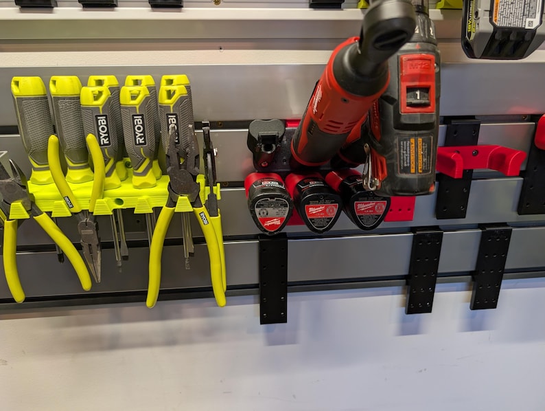 Puede incluir: Una colecci&oacute;n de herramientas, incluyendo alicates y herramientas el&eacute;ctricas, organizada en un sistema de almacenamiento montado en la pared. Las herramientas son una mezcla de herramientas manuales amarillas y negras y herramientas el&eacute;ctricas rojas y negras.