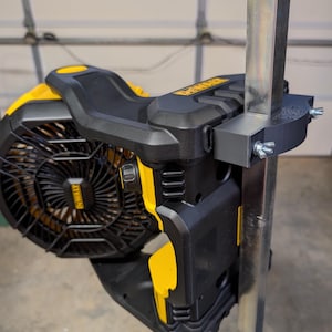 May include: A black and yellow portable fan with the "DEWALT" logo, mounted on a metal pole. The fan has a protective grill and is secured with a bracket and wingnuts. The fan is designed for portability and convenience.