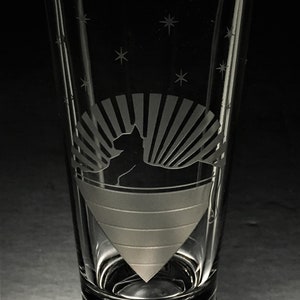 Könnte beinhalten: Ein klares Glas mit einem mattierten Design einer Katze, die vor einem Sonnenstrahl sitzt. Das Glas hat ein Sternenmuster um den oberen Rand.