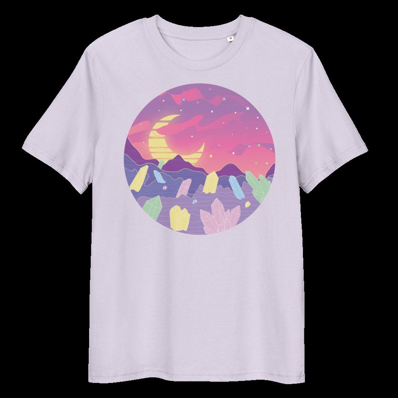 May include: A lavender t-shirt featuring a graphic of a crescent moon and a pink and purple sunset over a landscape of colourful crystals.