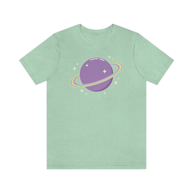 K&ouml;nnte beinhalten: Ein hellgr&uuml;nes T-Shirt mit einem lila Planeten mit einem Regenbogenring darum. Der Planet hat ein paar wei&szlig;e Sterne drumherum.