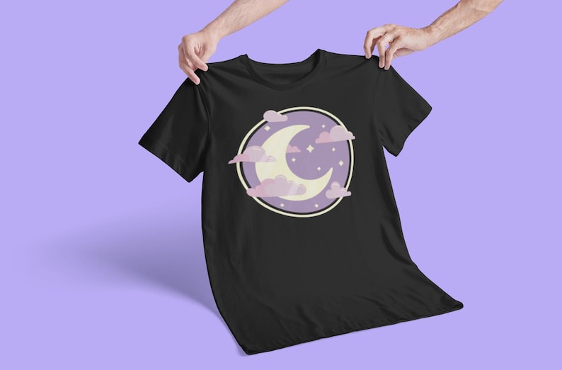 May include: Black t-shirt with a purple and white crescent moon and clouds graphic. The graphic is surrounded by a circle with a white outline.